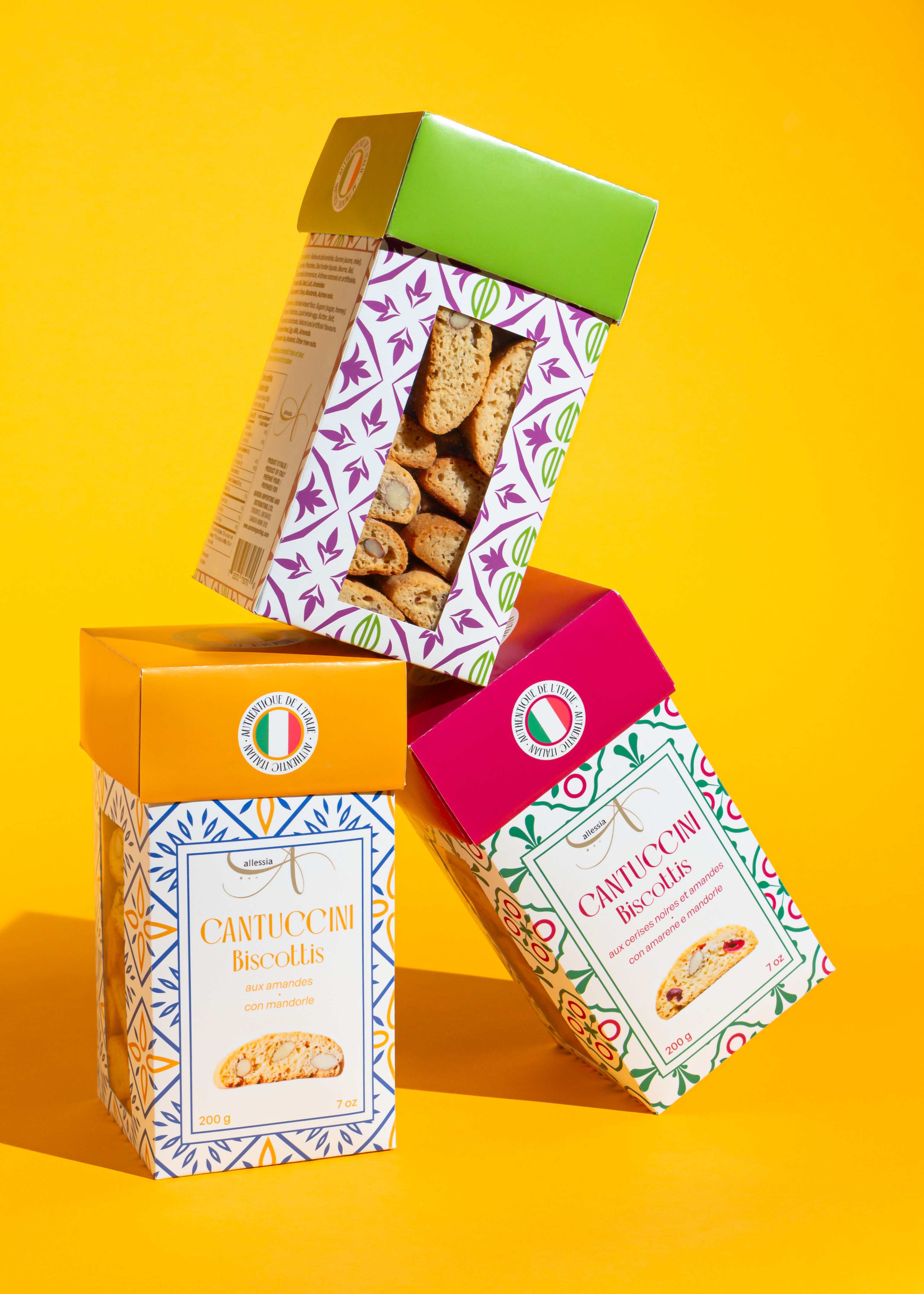 Boîtes de Cantuccini empilées en équilibre sur fond jaune