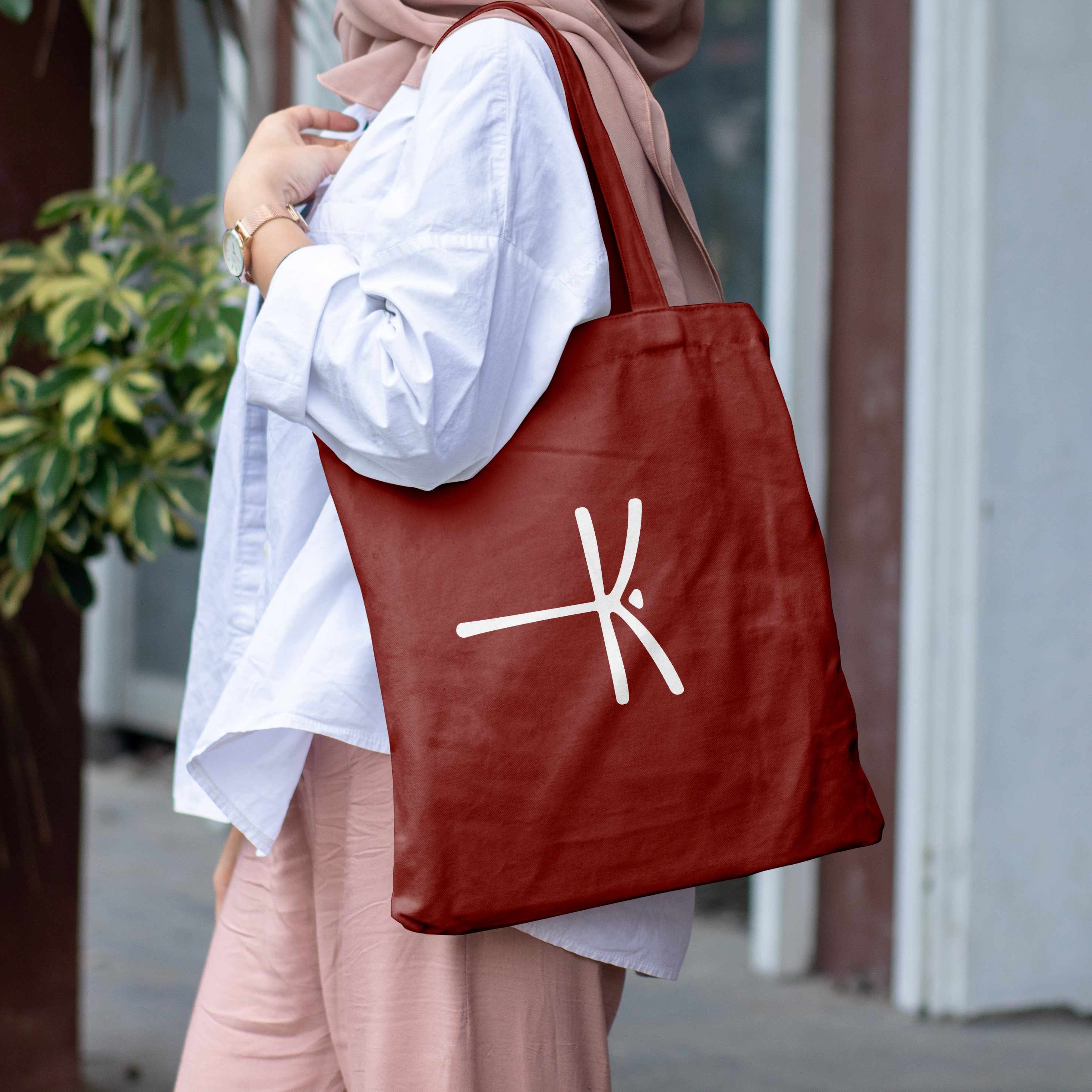 Femme portant un tote bag bordeaux Kinélibelula